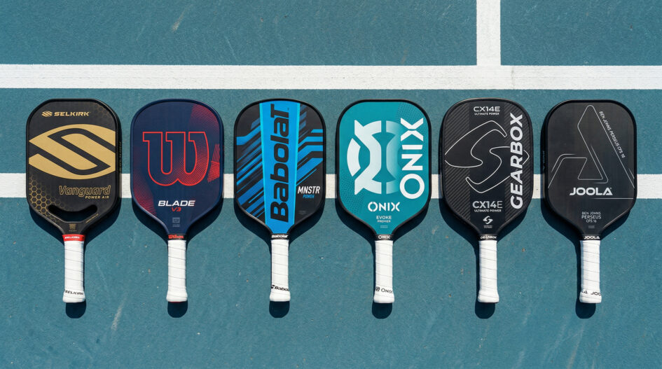 “Six pickleball paddles from Selkirk, Wilson, Babolat, Onix, Gearbox, and JOOLA arranged on a court for a brand comparison.”